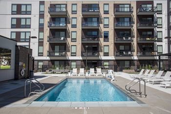 Outdoor pool with sundeck, chairs, and outdoor tv